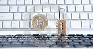 Bitcoin and padlock on the white computer keyboard