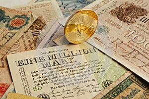 Bitcoin phisical coin with old german money. Cash Inflation. Cryptocurrency concept background. Closeup with copy space.