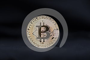 Bitcoin physical coin symbol on black background