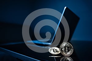 Bitcoin physical coin symbol with laptop background