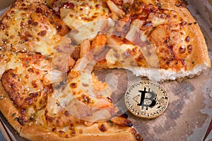 Bitcoin pizza day, physical golden bitcoin coin symbol and the pizza