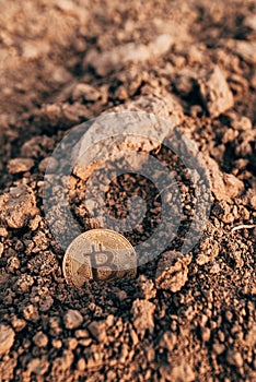 Bitcoin in plowed agricultural field soil