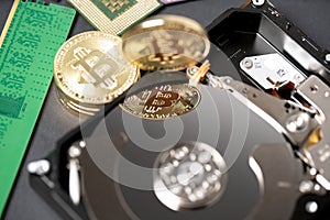 Bitcoin reflection on hard disk drive, cpu and ram stick in the background. Concept of crypto mining and digital currency