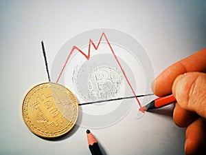 Bitcoin on a sheet of white paper. A hand-drawn graph with a drop in the rate of Bitocoin. The graph fell below zero photo