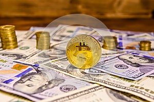 Bitcoin, stacks of the coins and one hundred dollar bills on wooden table