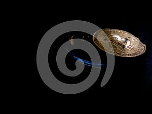 Bitcoin token rests against black background