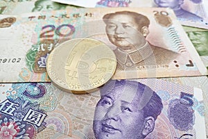 Bitcoin on top of a stack of Chinese Yuan banknotes