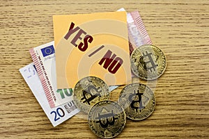 Bitcoins, Bit Coin on Euro, Dollars notes witch sticky note on wooden background, Yes No