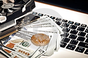 Bitcoins with dollar bills on laptop keyboard. Bitcoin. New virtual money. Video card, concept of mining.