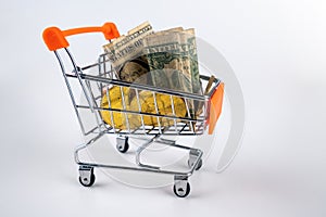 Bitcoins, euro, dollars and other currencies filling up shopping trolley, isolated on white background.