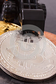 Bitcoins and miniature excavator, symbol of new virtual money and mining cryptocurrency