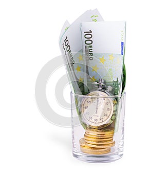 Bitcoins on a pile of one hundred euros and a bulb clock on empy glass.