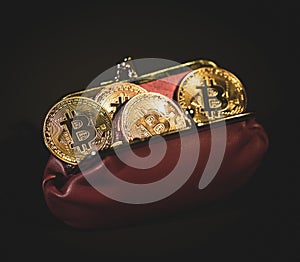 Bitcoins in red leather wallet on black