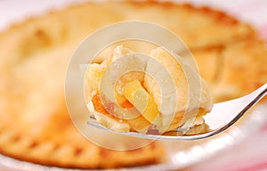 Bite of apple pie on a fork