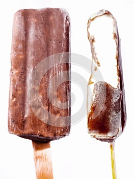 Bite ice cream covered by brown chocolate isolated on white background