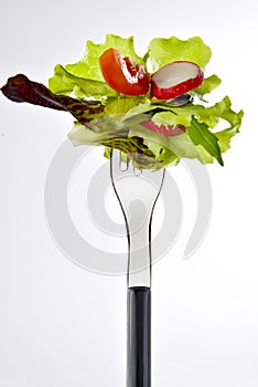 Bite of mixed salad on fork photo