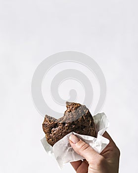 Bite shapes chocolate chips cookie in a hand. Isolated on white.