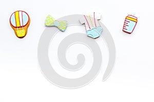 Bith of child concept. Cookies in shape of baby cloth and baby bottle on white background top view copy space