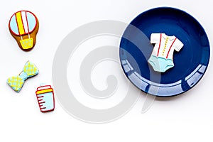 Bith of child concept. Cookies in shape of baby cloth and baby bottle on white background top view space for text