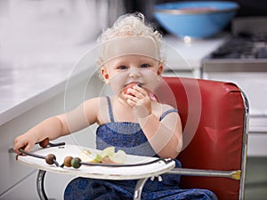 Biting into that apple. A cute baby girl with curly hair biting into an apple.