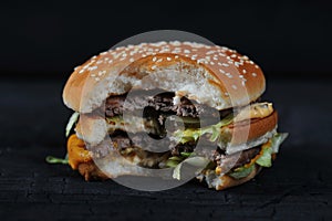 Bitten burger on a dark rustic photo