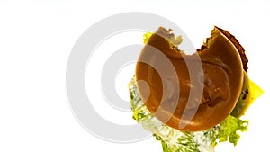 Bitten cheeseburger lying on white illuminated background, testing food quality