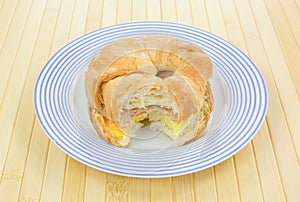 Bitten sausage egg and cheese croissant breakfast sandwich