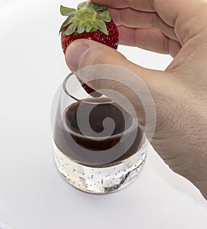 Bitten strawberry chocolate liqueur hand