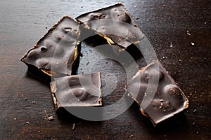 Bitter Almond Chocolate Pieces on Dark Wooden Surface
