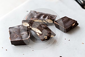 Bitter Almond Chocolate Pieces on White Marble Surface