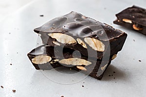 Bitter Almond Chocolate Pieces on White Marble Surface