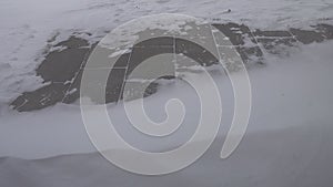 Bitter Cold Wind And Snow over pedestrian road plates  small vortex over plates and snow