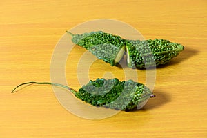 Bitter gourd green pieces closeup on isolated table background