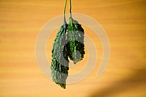 Bitter gourd green pieces closeup on isolated table background