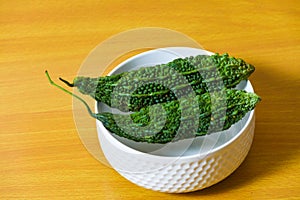 Bitter gourd green pieces closeup on isolated table background