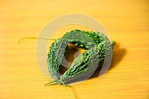 Bitter gourd green pieces closeup on table background