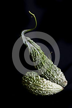 Bitter gourd vegetables on a plain black background