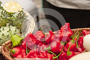 Bitter hot red peppers of different varieties of the farmer in a basket lie in the window of the farmer`s market. The latest