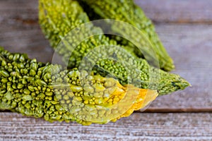 Bitter melon fresh organic green herb or vegetable, bitter cucumber or bitter cucumber on old wooden background