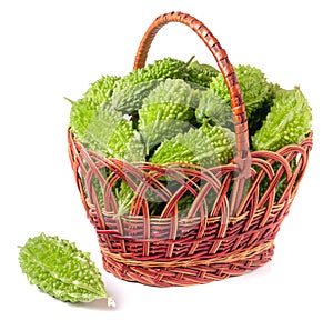 Bitter melon or momordica in a wicker basket isolated on white background