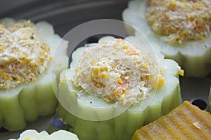 Bitter melon stuffed with vermicelli, tofu, corn and carrot while steaming in steaming pot