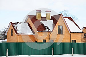 Bitumen asphalt shingles roof. Two chimneys on the roof of the house individual heating.