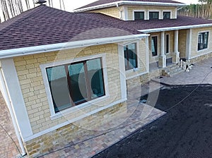 Bituminous tile for a roof. House with a roof from a bituminous