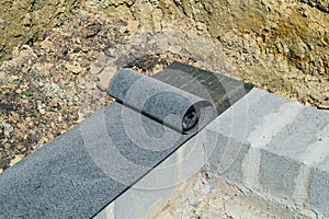 Bituminous waterproofing roll material is laid on wall of concrete blocks photo