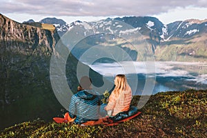 Bivouac in mountains couple man and woman in sleeping bags camping gear, travel hiking in Norway photo