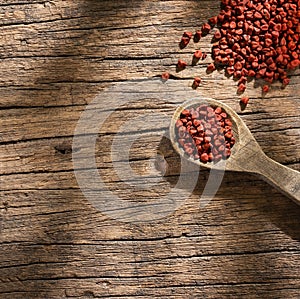 Bixa Orellana - Organic achiote seeds in wooden spoon