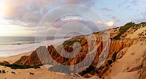 Bizarre eroded sand dunes on the Atlantic Ocean with waves rolling in at sunset