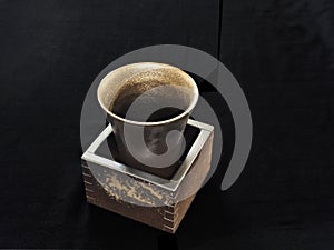 Bizen-yaki or Bizen ware cup and square box on black background photo