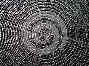 Black abstract woven surface with spiral circles