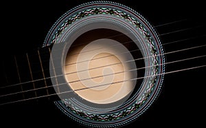 Black acoustic guitar soundhole closeup